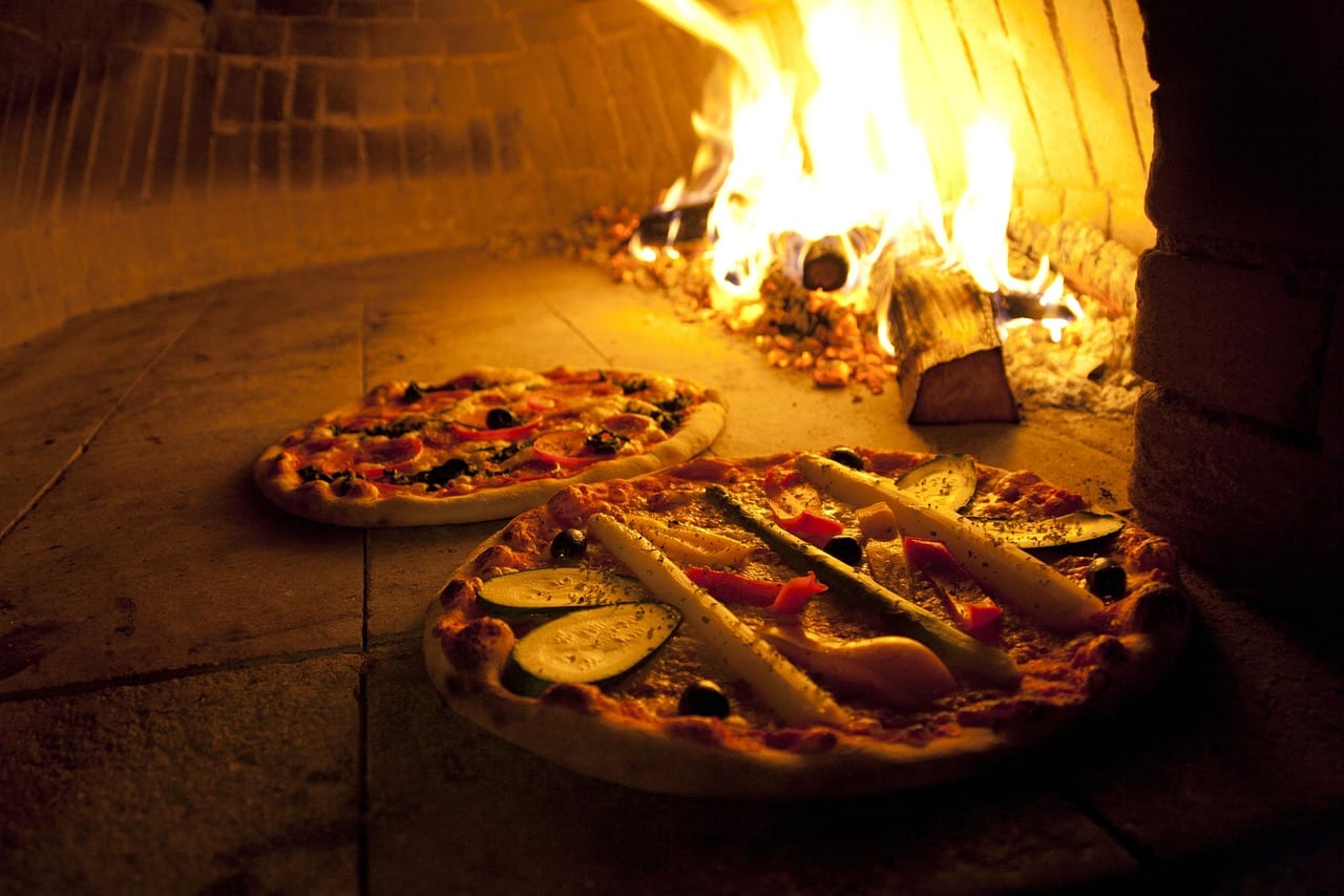 Pizzas baking in the wood-fired oven at Ember & Olive