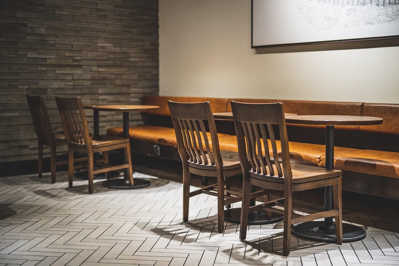 Wooden chairs and a leather banquette in the Ember & Olive dining room